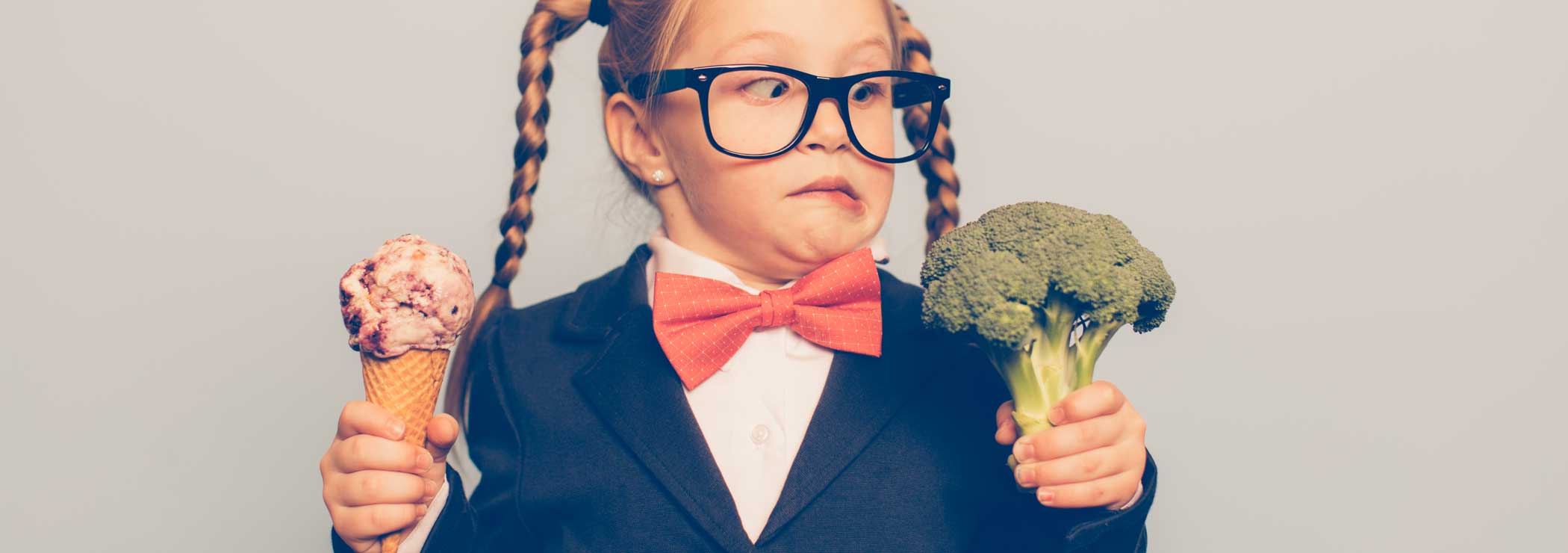 Ein Mädchen hat die Wahl von Glace oder Gemüse