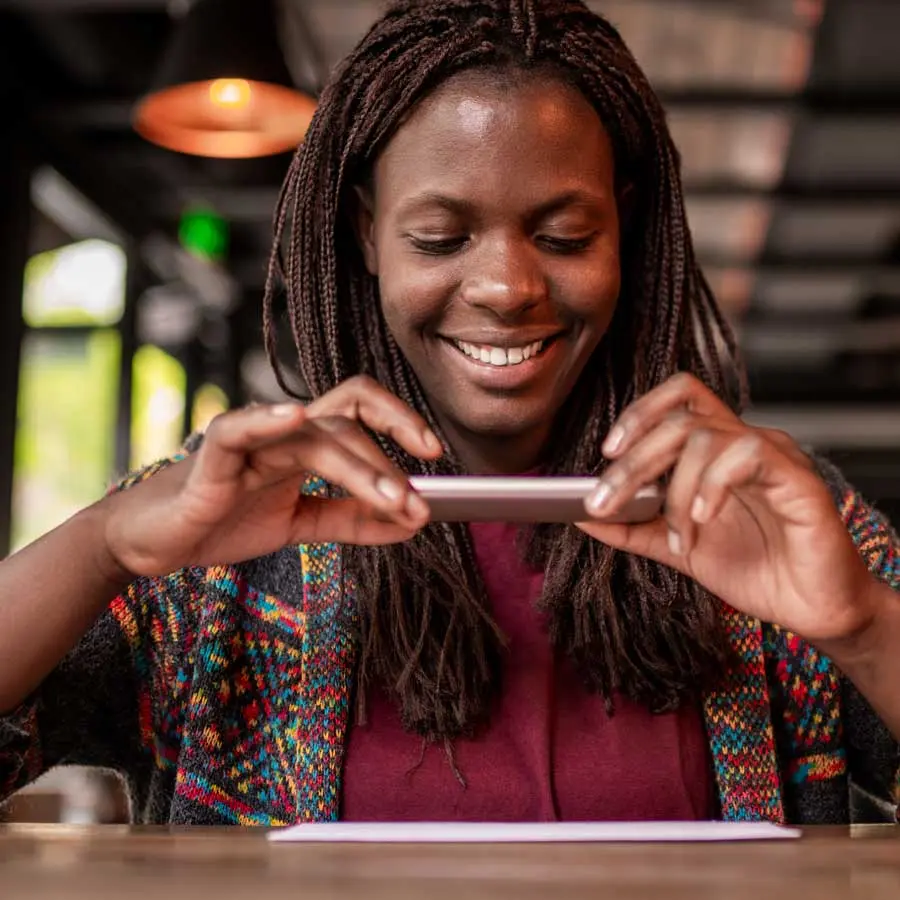 Women takes a picture of something on a table using a smartphone   