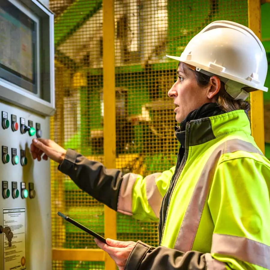 Arbeiterin überwacht industrielle Steuerungssysteme