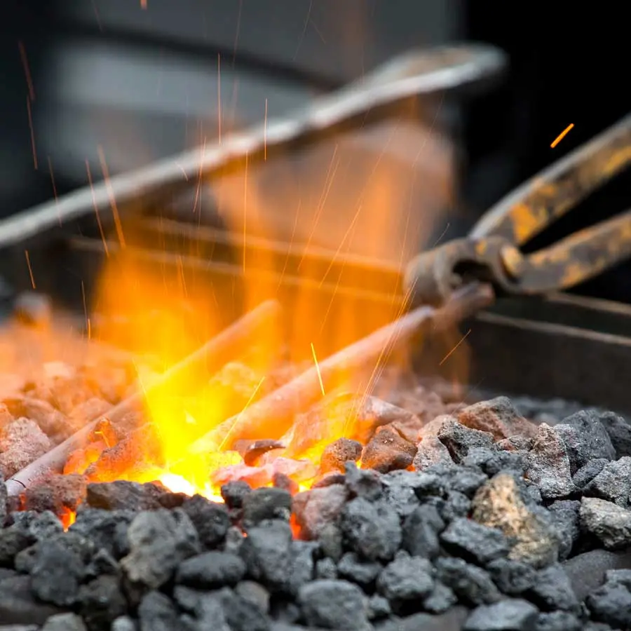 A piece of metal is heated in the forge