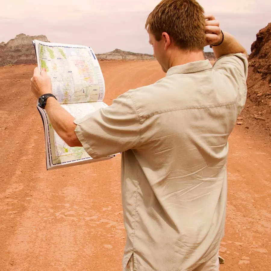 Man with map scratches his head