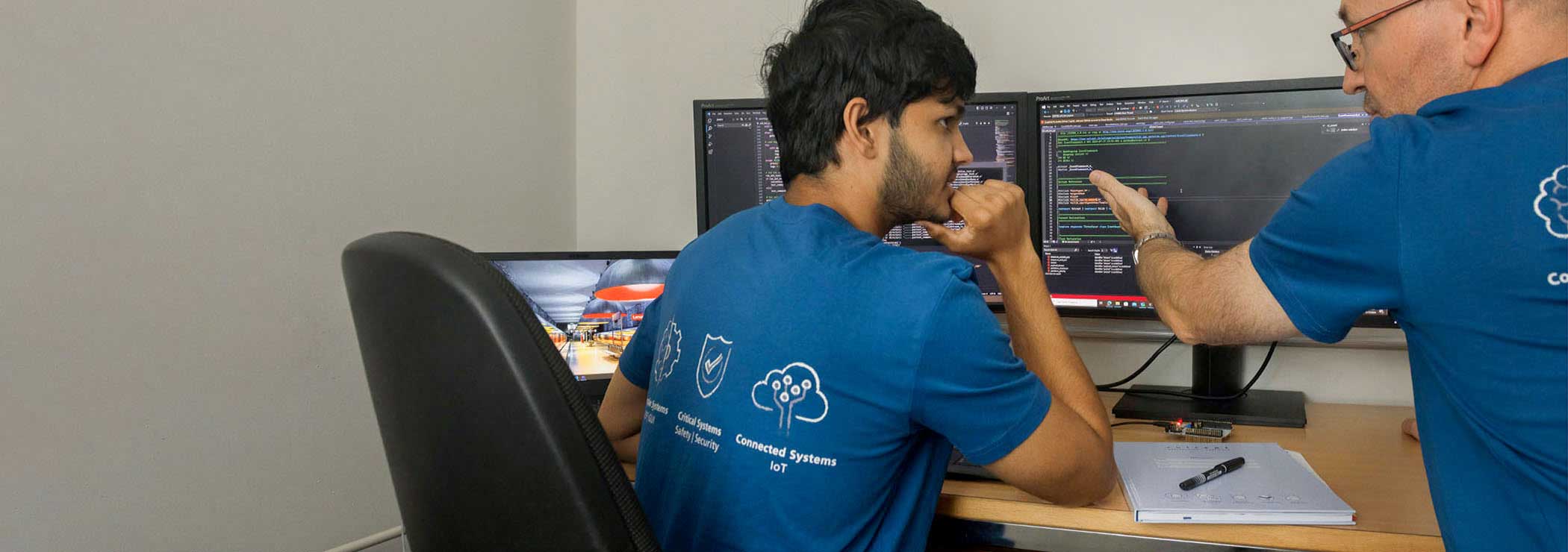 The mentor discusses with the trainee at the screen