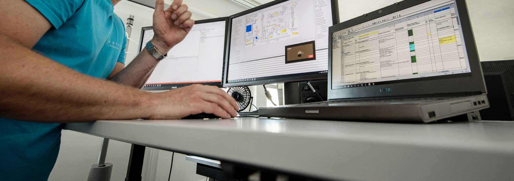 Software developer working on three screens