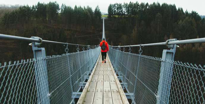 Man walking on a foot suspension bridge