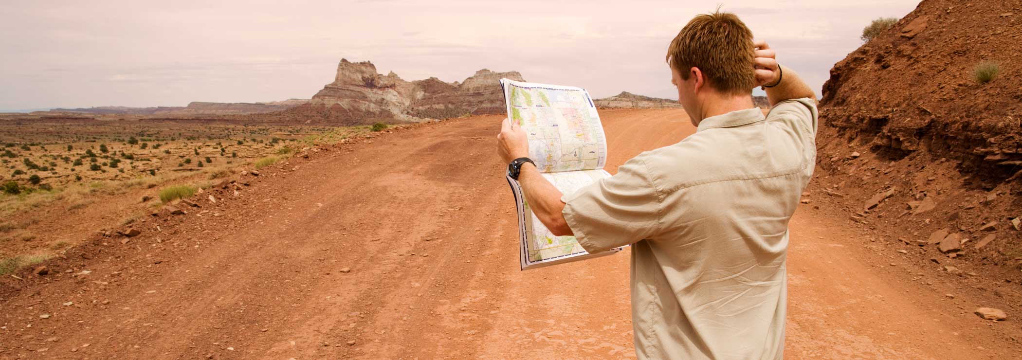 Man with map scratches his head