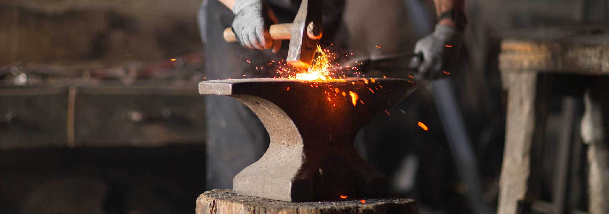 Blacksmith forges a hot workpiece on the anvil