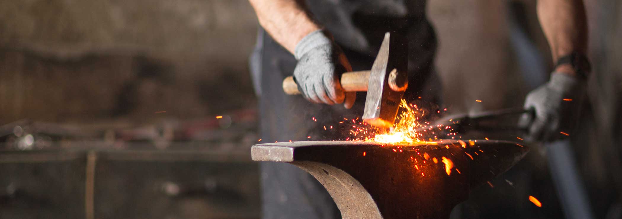 Blacksmith forges a hot workpiece on the anvil