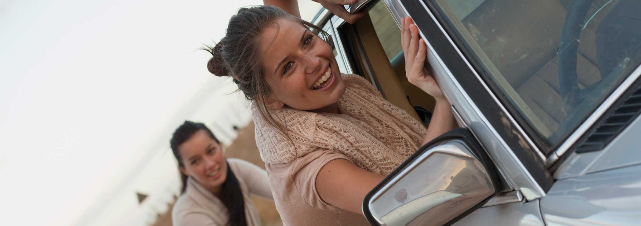 Women push a broken down car