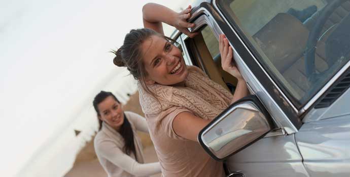Women push a broken down car