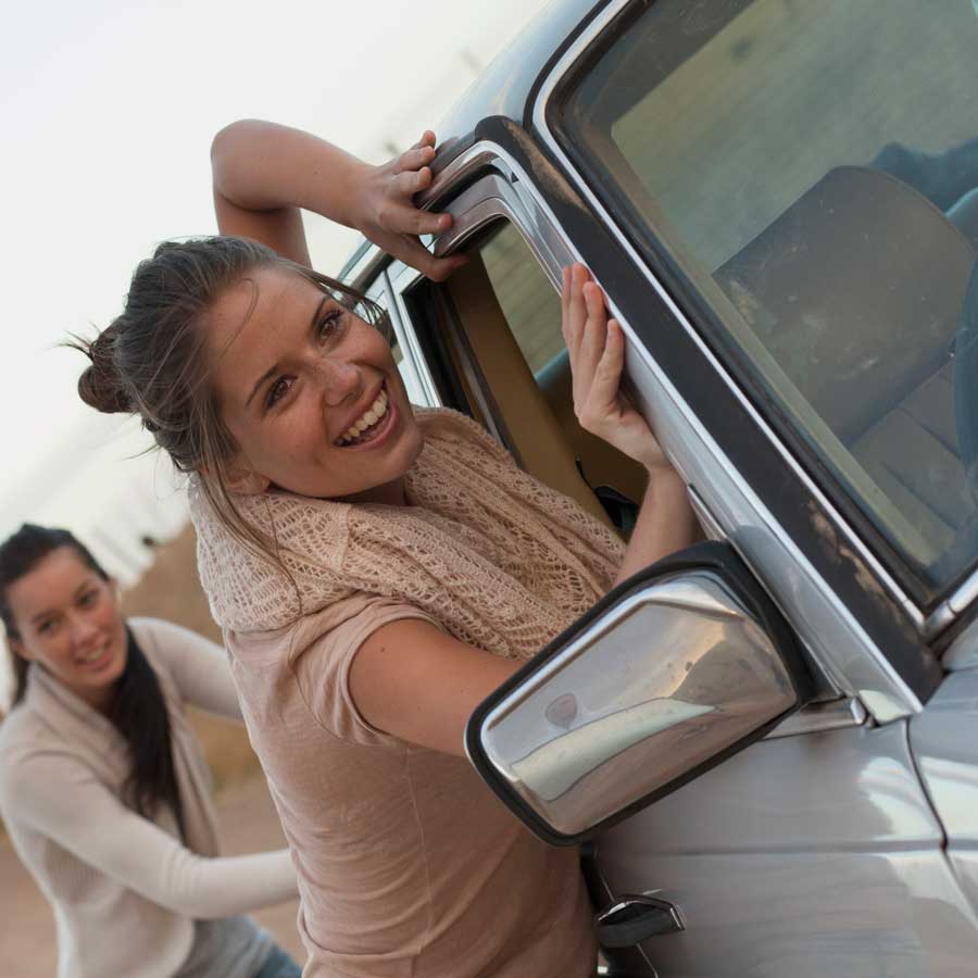 Women push a broken down car